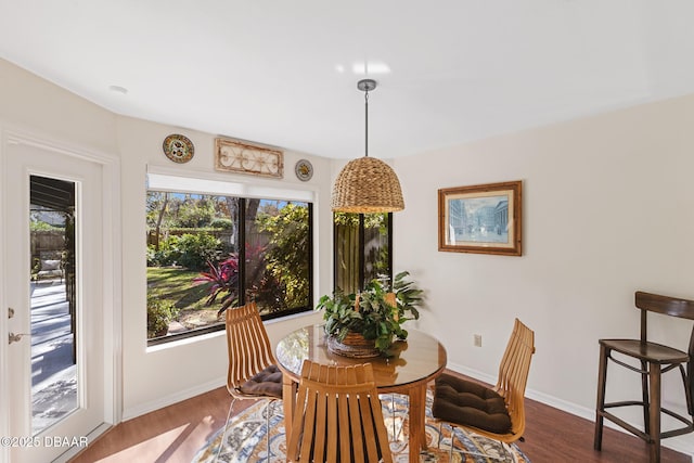 dining space featuring wood finished floors and baseboards