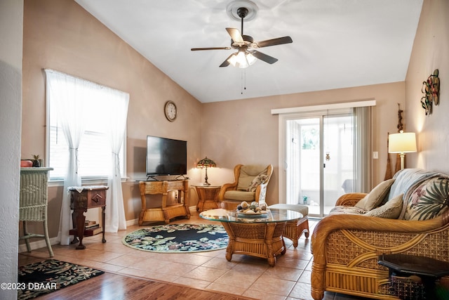 living room with ceiling fan, light tile patterned flooring, and vaulted ceiling