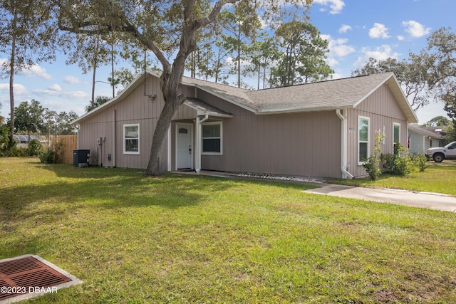 single story home with central air condition unit and a front lawn