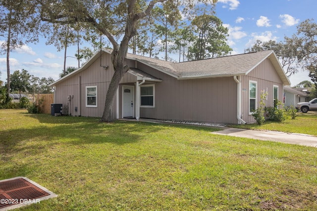 2835 Nordman Ave, New Smyrna Beach, FL 32168 - view of front facade featuring central AC, a front yard, and roof with shingles