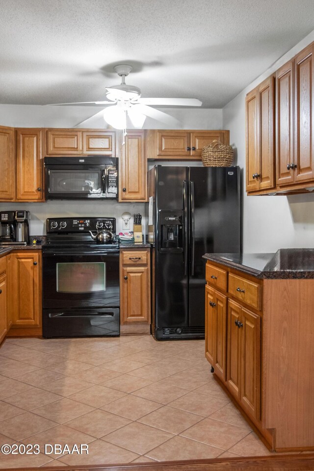 2835 Nordman Ave, New Smyrna Beach, FL 32168 - kitchen featuring black appliances, a ceiling fan, brown cabinetry, light tile patterned floors, and a textured ceiling