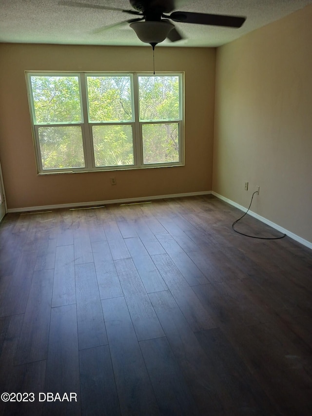 unfurnished room featuring a textured ceiling, plenty of natural light, hardwood / wood-style flooring, and ceiling fan