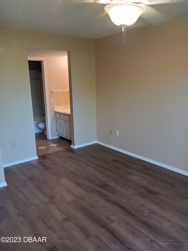 spare room with a textured ceiling and dark hardwood / wood-style floors