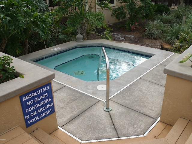 view of swimming pool with a community hot tub