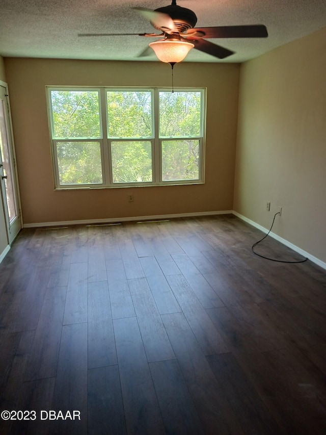 spare room featuring a wealth of natural light, ceiling fan, a textured ceiling, and hardwood / wood-style flooring