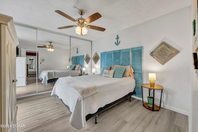 bedroom featuring ceiling fan, a closet, a textured ceiling, and light wood-type flooring