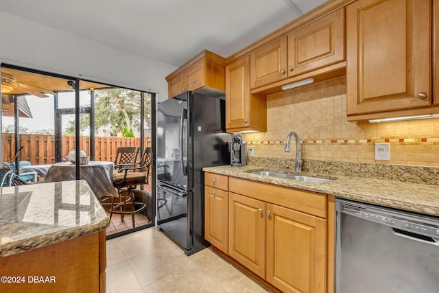 kitchen with sink, dishwasher, black refrigerator, backsplash, and light stone counters