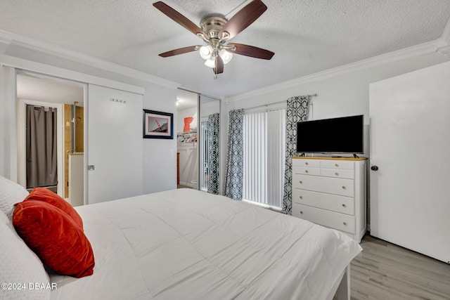 bedroom with crown molding, ceiling fan, light hardwood / wood-style floors, and a textured ceiling