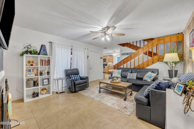 living room with light tile patterned flooring, a textured ceiling, and ceiling fan