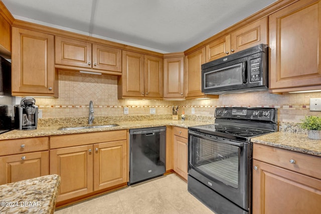 kitchen with sink, backsplash, light stone counters, and black appliances