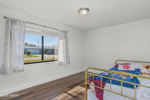 bedroom featuring wood finished floors and baseboards