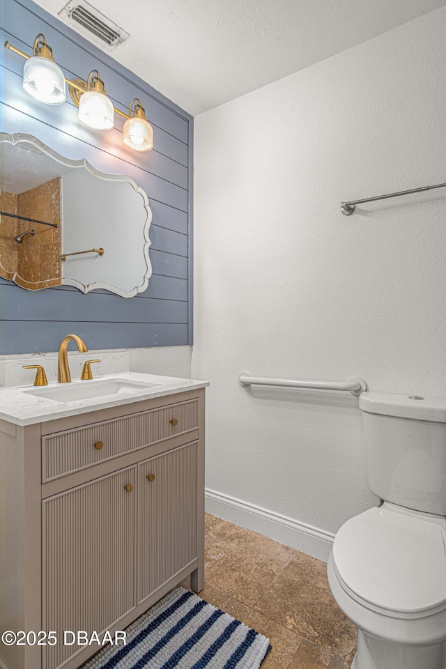 bathroom featuring visible vents, vanity, toilet, and baseboards