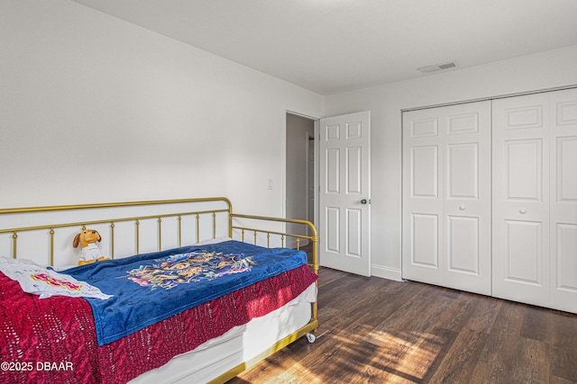 bedroom featuring a closet, visible vents, and wood finished floors