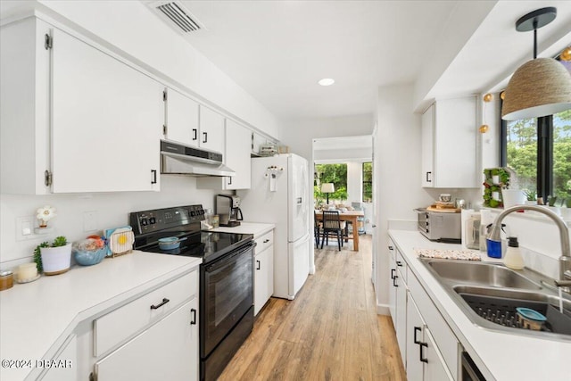 kitchen with white cabinets, sink, electric range, pendant lighting, and light wood-type flooring