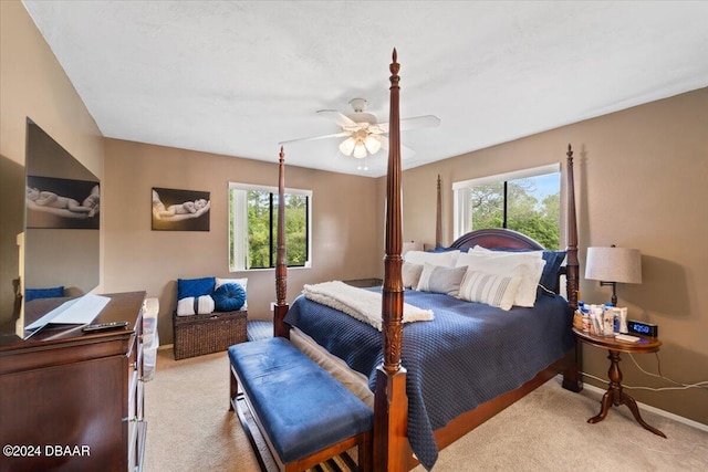 bedroom featuring light carpet, multiple windows, and ceiling fan