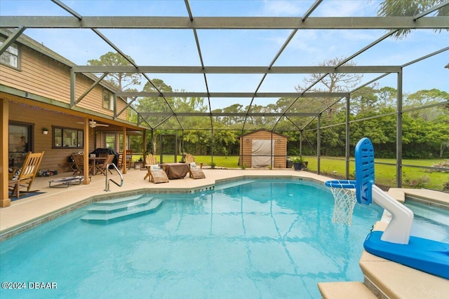 view of swimming pool featuring a storage shed, outdoor lounge area, glass enclosure, and a patio