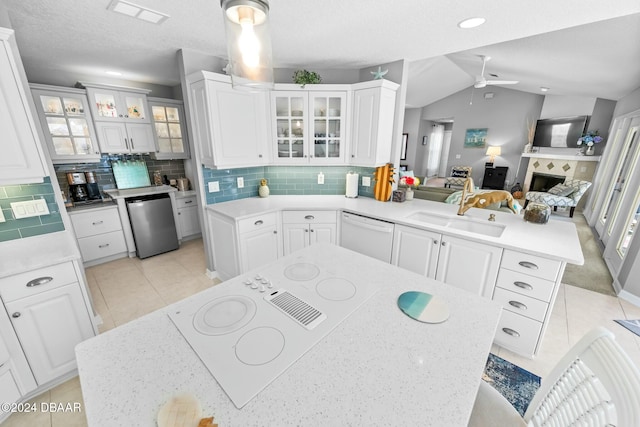 kitchen featuring dishwasher, backsplash, white dishwasher, sink, and kitchen peninsula