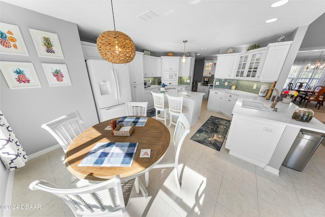 kitchen featuring white cabinets, white appliances, decorative light fixtures, and sink