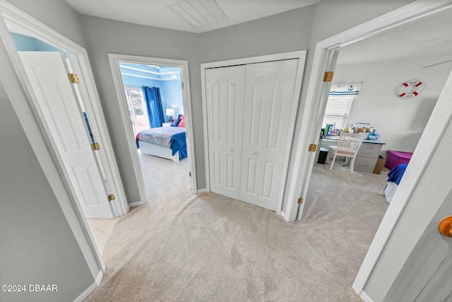 hallway featuring light colored carpet and a healthy amount of sunlight