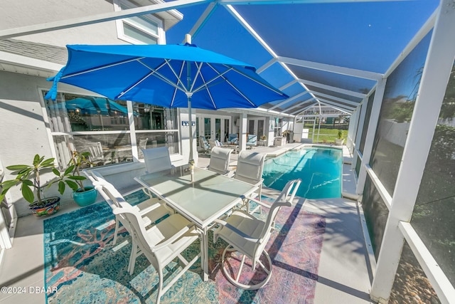 view of pool with a patio and glass enclosure