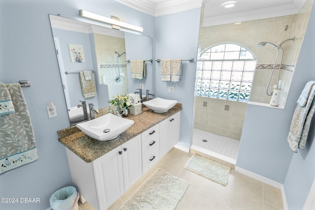 bathroom featuring tile patterned flooring, vanity, ornamental molding, and tiled shower