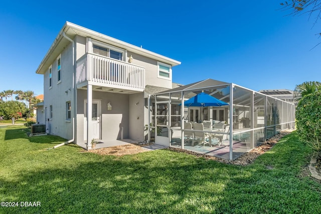 back of house with a lanai, a balcony, cooling unit, and a lawn