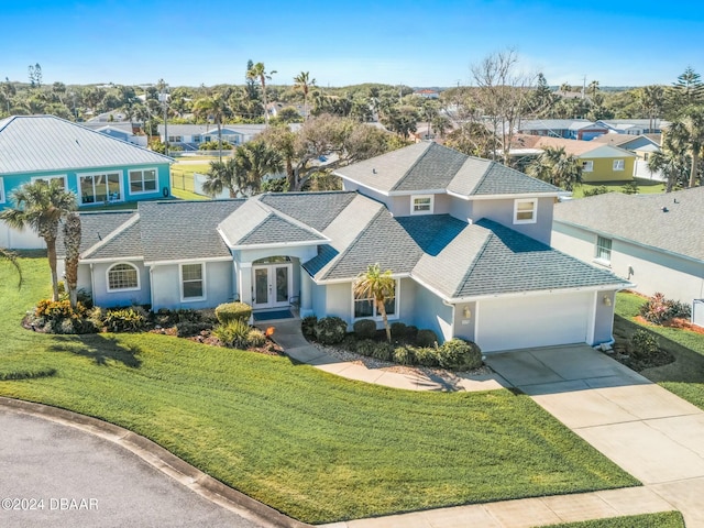 view of front of property featuring a front yard, french doors, and a garage