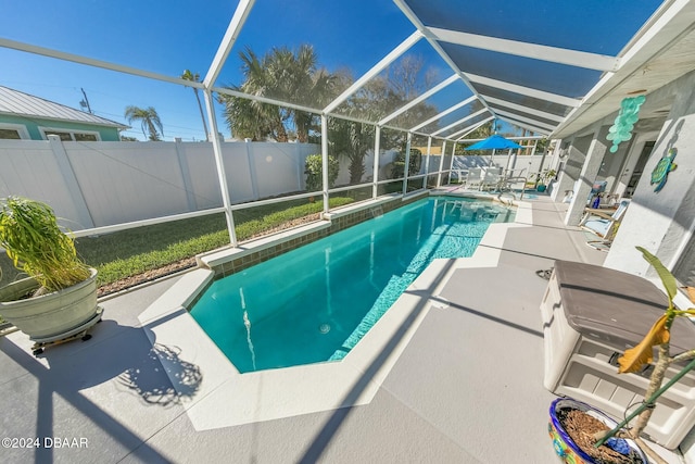 view of swimming pool featuring a lanai and a patio area