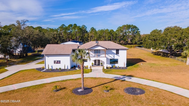 view of front of property featuring a front lawn and a balcony