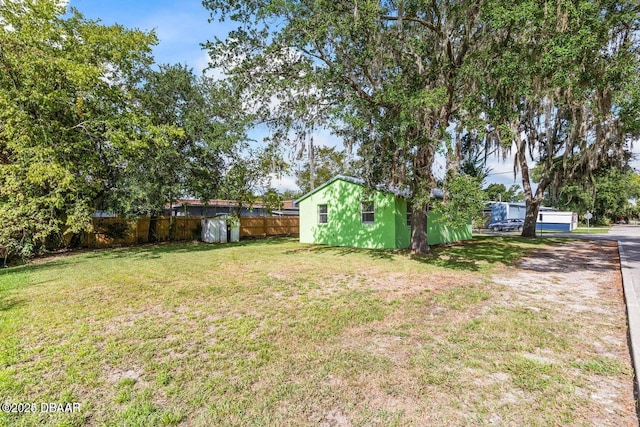 view of yard featuring an outbuilding and fence