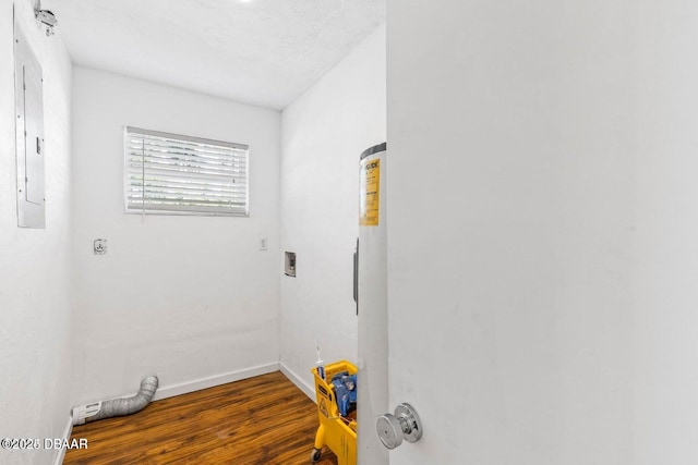 washroom with electric dryer hookup, electric panel, wood finished floors, baseboards, and laundry area