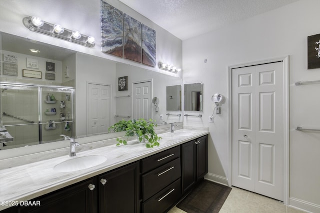 47 Abacus Ave, Ormond Beach, FL 32174 - full bath featuring double vanity, tile patterned floors, a shower stall, baseboards, and a textured ceiling
