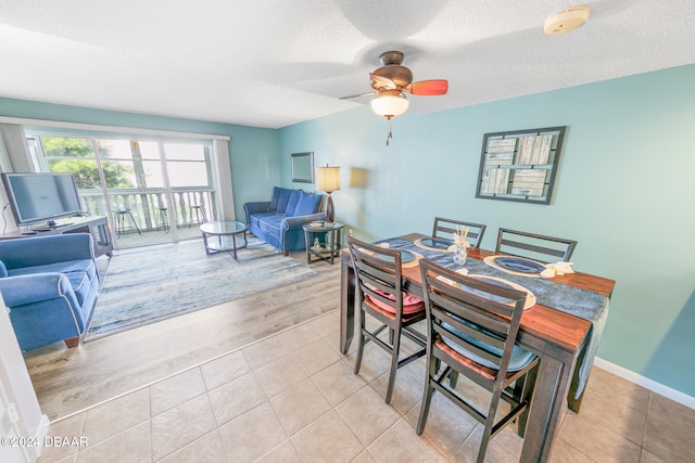 dining space featuring ceiling fan, light tile patterned floors, and a textured ceiling