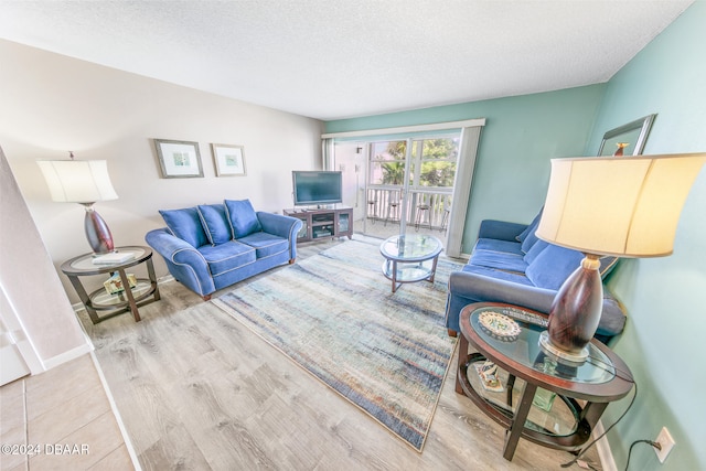 living room with light wood-type flooring and a textured ceiling