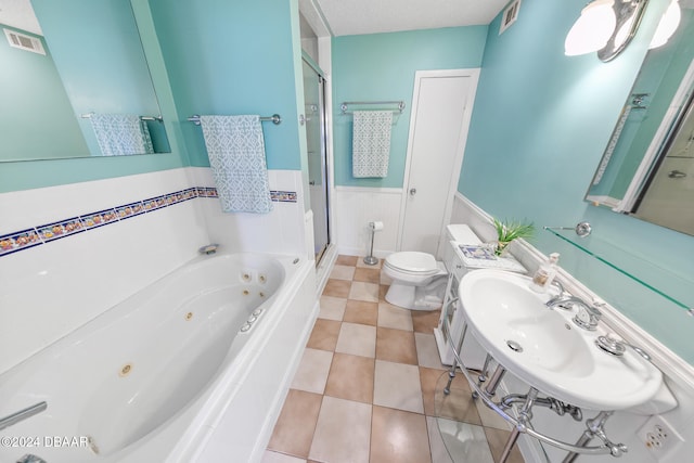 full bathroom featuring separate shower and tub, sink, a textured ceiling, and toilet