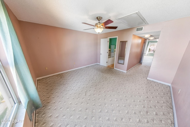 carpeted spare room featuring ceiling fan and a textured ceiling