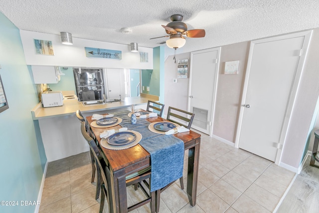 dining area featuring light tile patterned floors, a textured ceiling, and ceiling fan