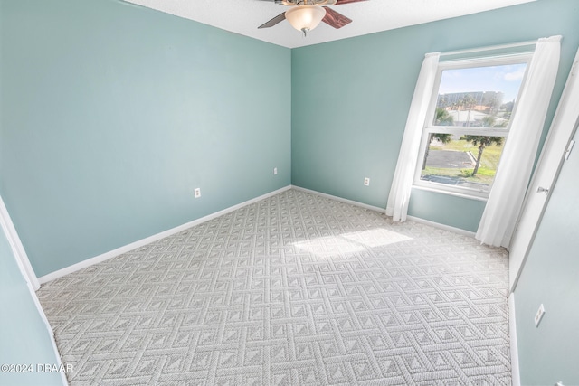 empty room featuring light colored carpet and ceiling fan