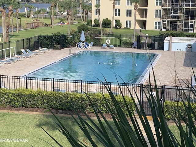 view of swimming pool with a patio area and a lawn