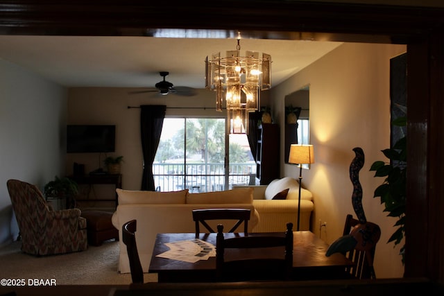 dining room with carpet and ceiling fan with notable chandelier