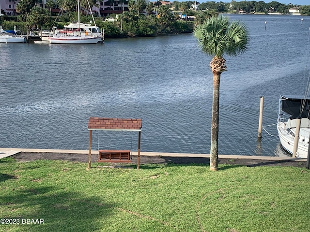 dock area with a yard and a water view