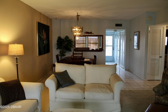 living room with light tile patterned floors and a notable chandelier