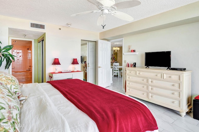 2425 S Atlantic Ave Unit 202, Daytona Beach, FL 32118 - bedroom with a textured ceiling, light marble finish floors, ensuite bath, a chandelier, and ceiling fan