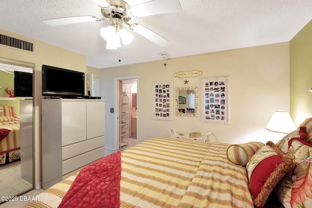 2425 S Atlantic Ave Unit 202, Daytona Beach, FL 32118 - bedroom featuring a textured ceiling, a ceiling fan, and connected bathroom