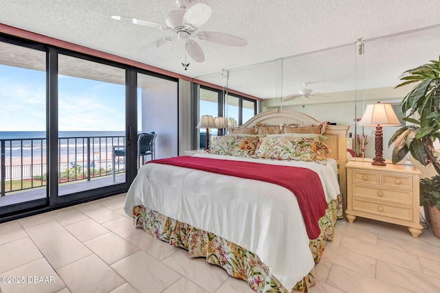 2425 S Atlantic Ave Unit 202, Daytona Beach, FL 32118 - bedroom with multiple windows, access to outside, a textured ceiling, marble look tiles, and a water view
