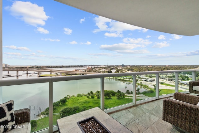 balcony with a water view and a fire pit