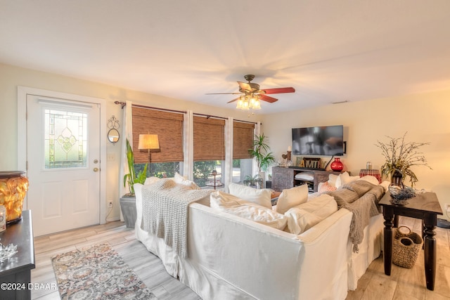 living room with ceiling fan and light hardwood / wood-style flooring