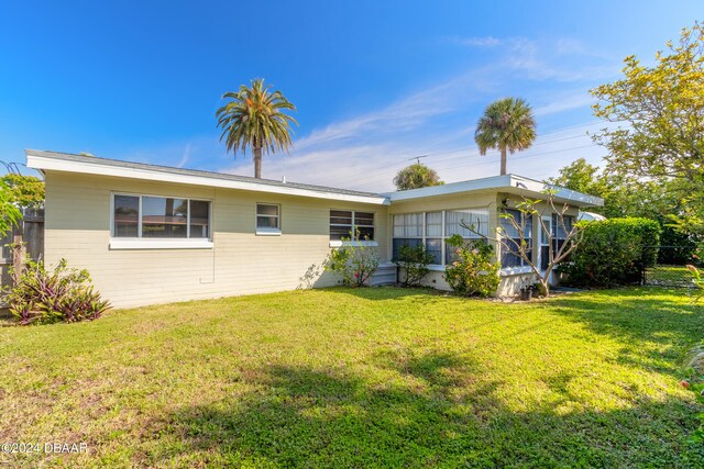 rear view of property featuring a lawn