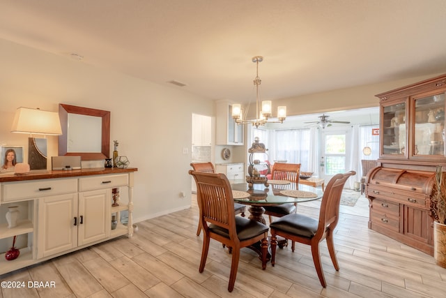 dining space featuring ceiling fan with notable chandelier and light hardwood / wood-style flooring