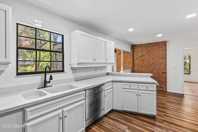 4 Eagle Rock Trl, Ormond Beach, FL 32174 - kitchen with stainless steel dishwasher, a sink, light countertops, dark wood-style flooring, and a peninsula